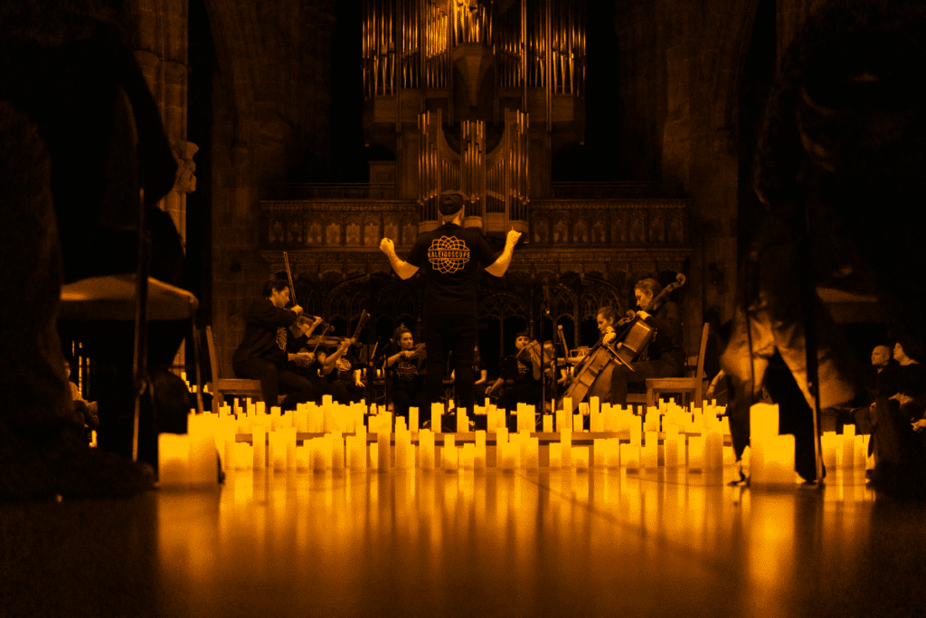 Manchester Cathedral illuminated by candlelight while musicians perform