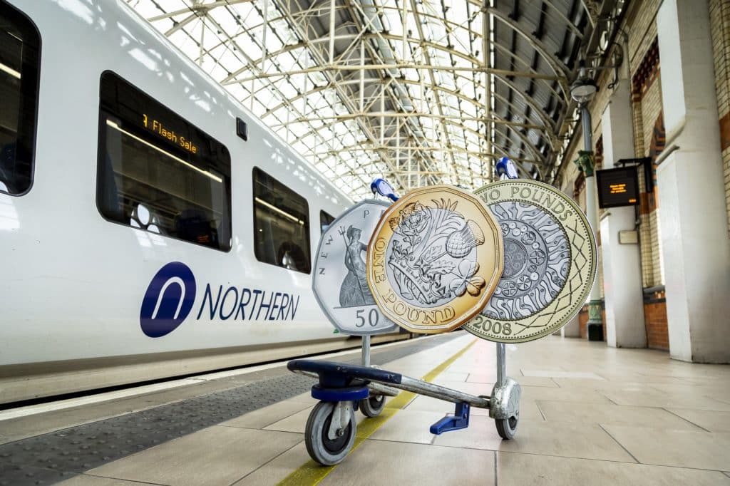 northern-train-next-to-pound-fifty-pence-coins-on-luggage-trolley
