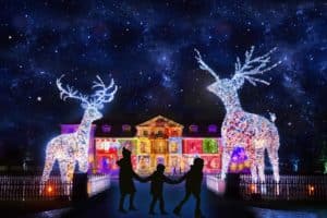 dunham-massey-house-lit-up-with-colourful-lights-and-glittering-deer-sculptures-in-foreground