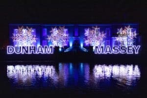dunham-massey-house-altrincham-near-manchester-lit-up-in-blue-purple-lights-with-water-reflection