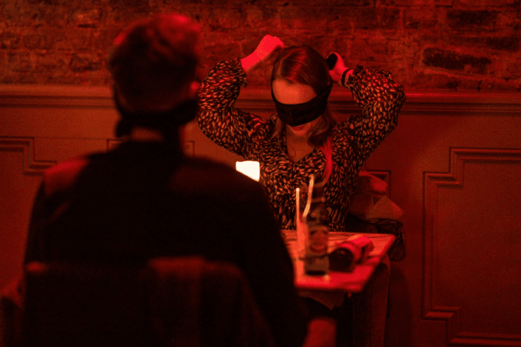 A woman putting on her blindfold at the Dining in the Dark experience.