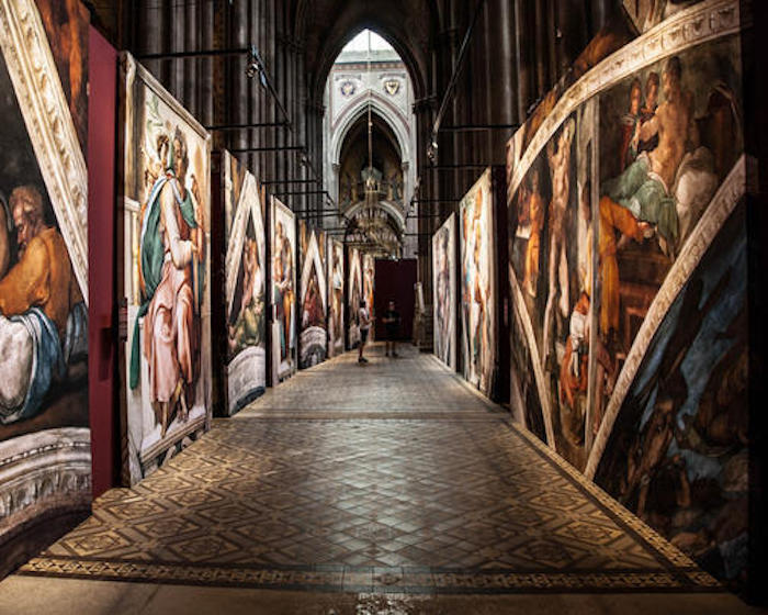 a corridor of canvases depicting parts of the Sistine Chapel ceiling