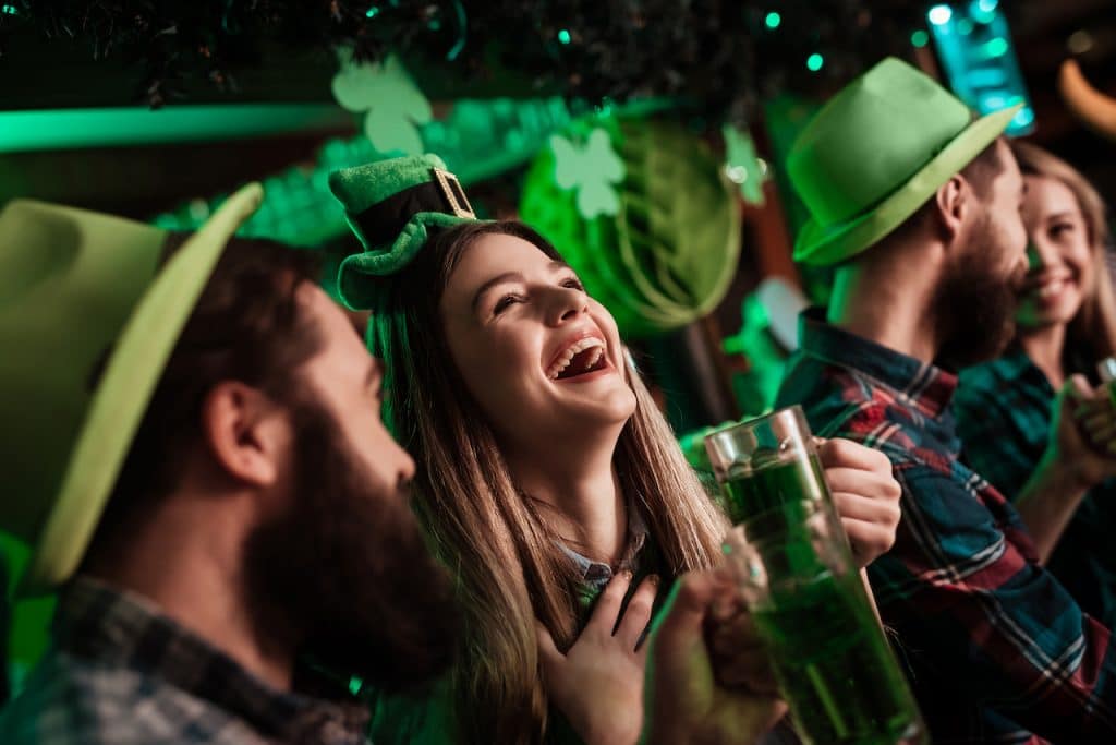 a group of people celebrating st Patrick's day in green headwear for Paddy's Fest Party