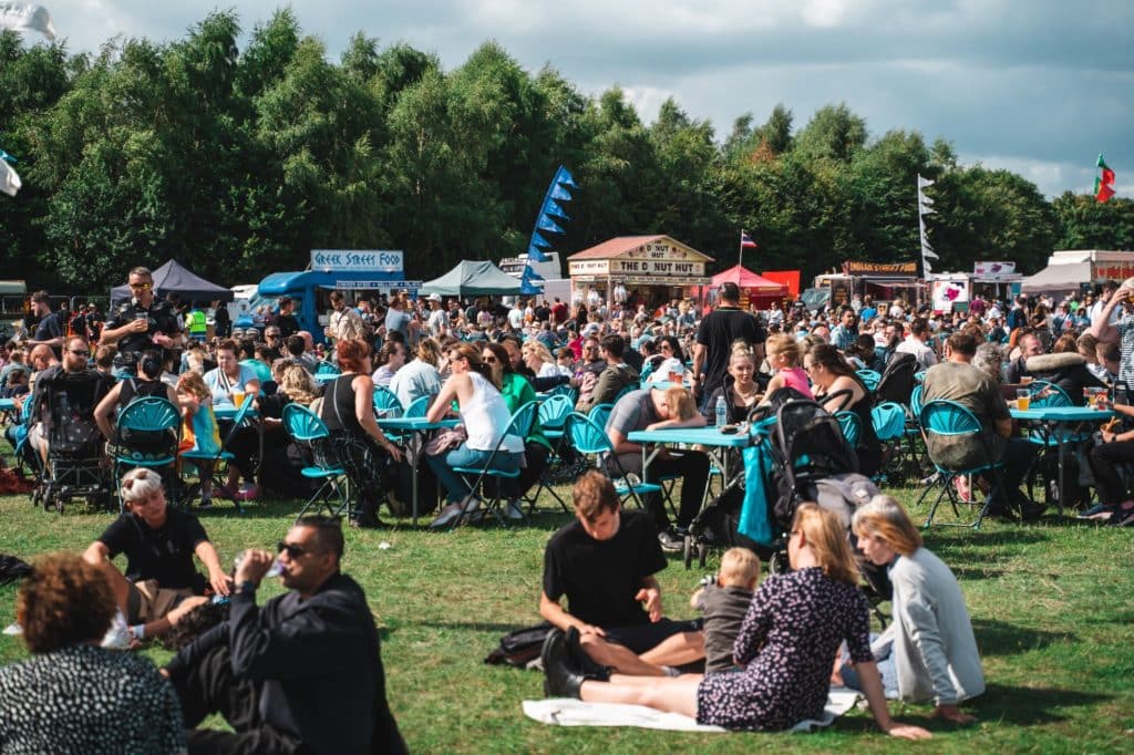 heaton-park-food-festival-people-sat-in-park-surrounded-by-food-stalls
