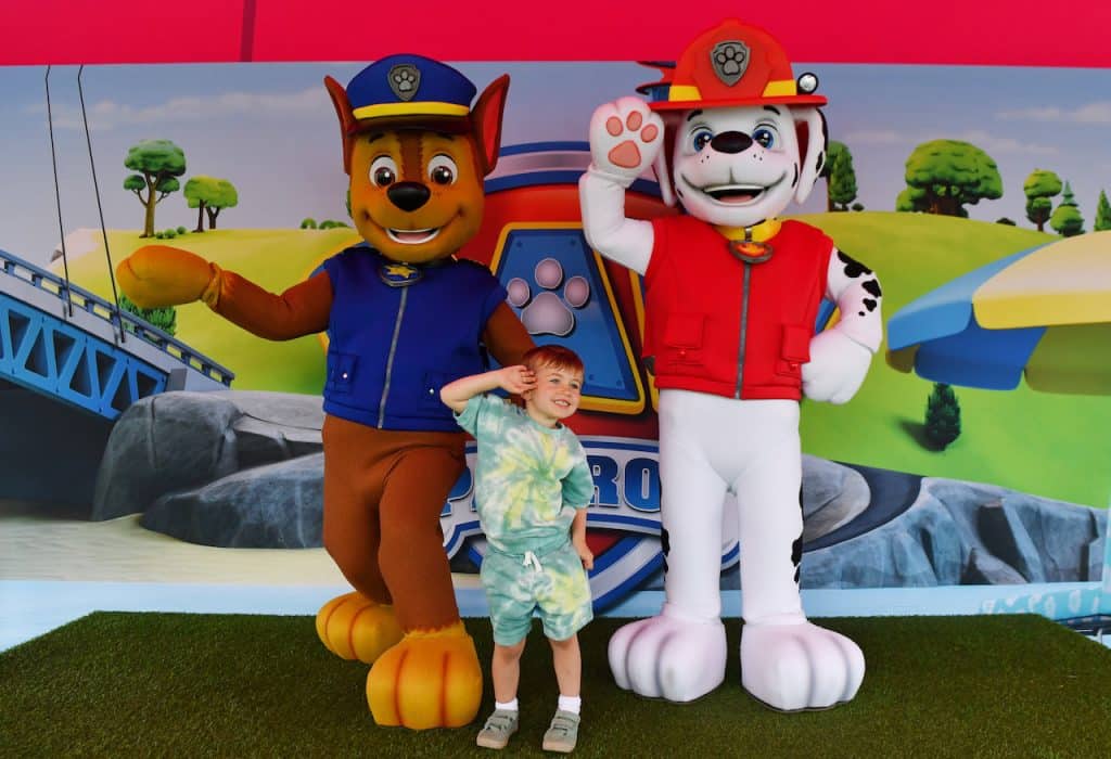 a child with two characters from PAW Patrol at The Nickelodeon Experience