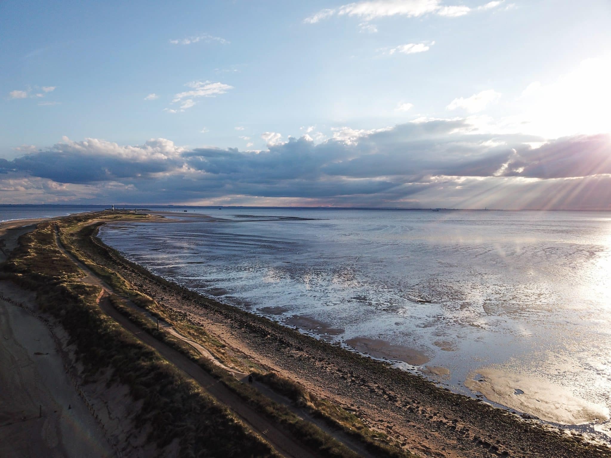 A shot of Spurn Point near Hull with clouds in the sky and the sun shining on a summer day.