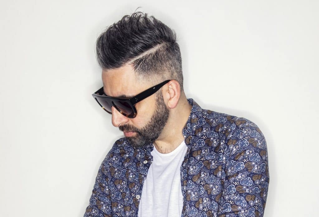 DJ Darius Syrossian looks down in sunglasses