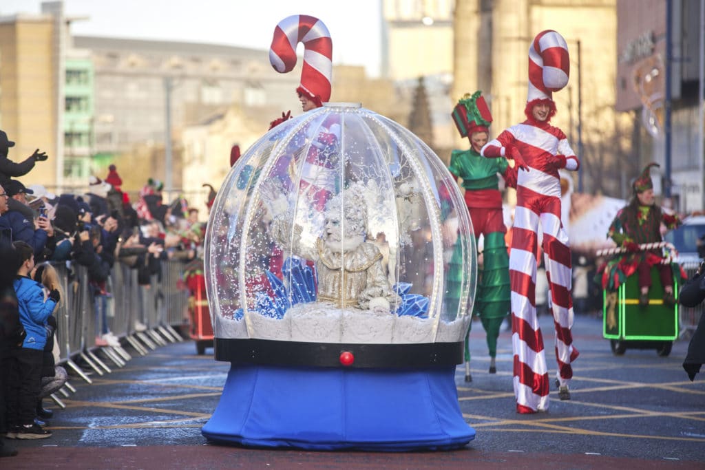 candy-cane-stilt-walkers-and-snow-globe-at-manchester-christmas-parade