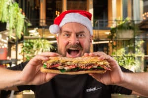 sndwch-founder-holding-festive-sandwich-wearing-santa-hat
