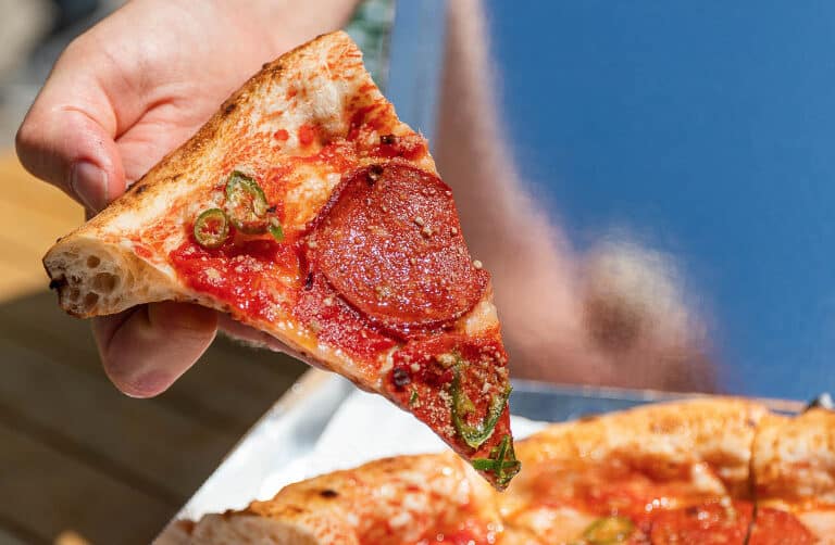 slice-pepperoni-pizza-held-up-free-vegan