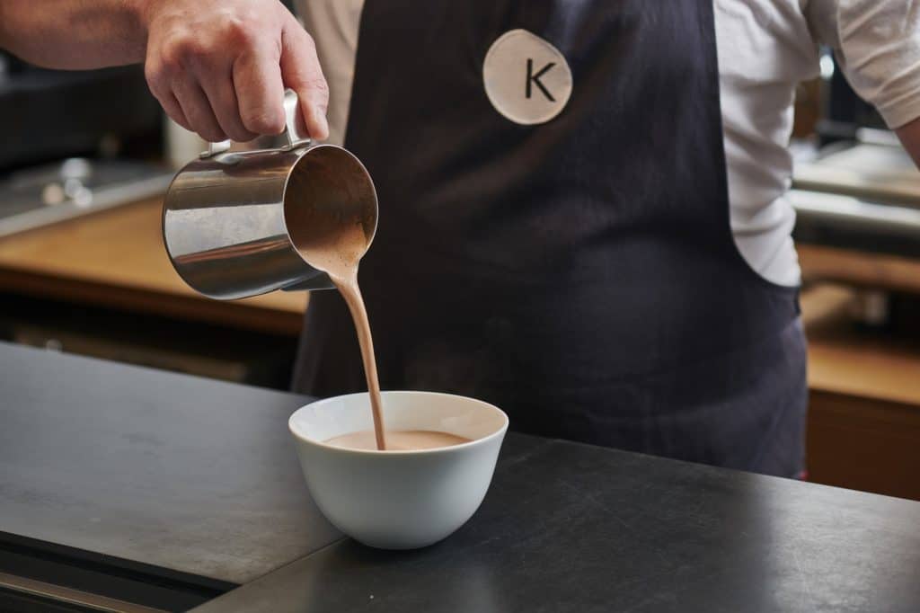 man-pouring-hot-chocolate-at-knoops-into-cup