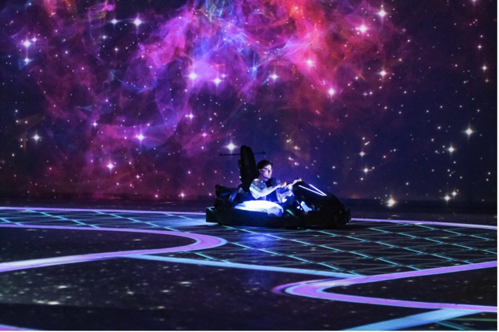 digital-purple-background-person-sat-in-go-kart-at-chaos-karts-which-is-coming-to-manchester
