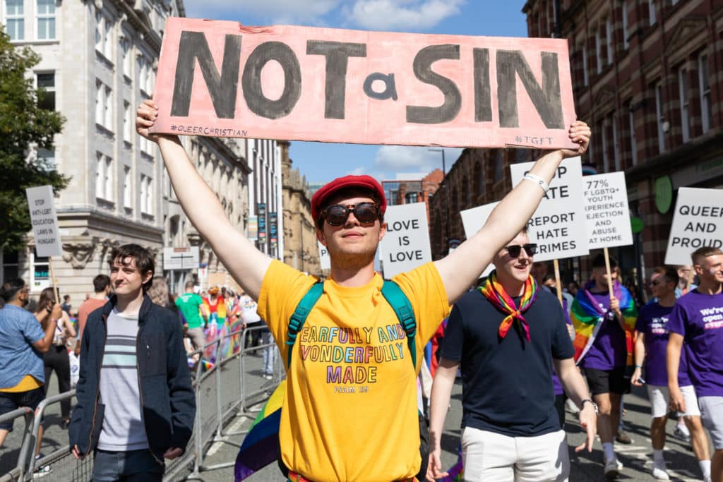 person-holding-sign-saying-not-a-sin-at-manchester-pride-parade