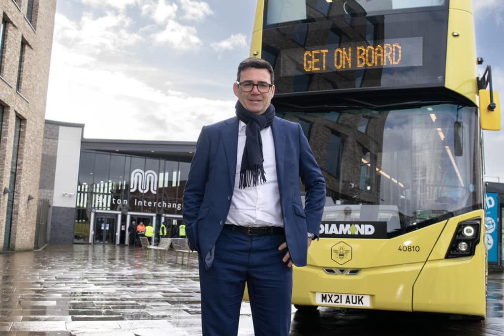 andy-burnham-in-front-of-one-of-the-yellow-buses-being-rolled-out-in-greater-manchester