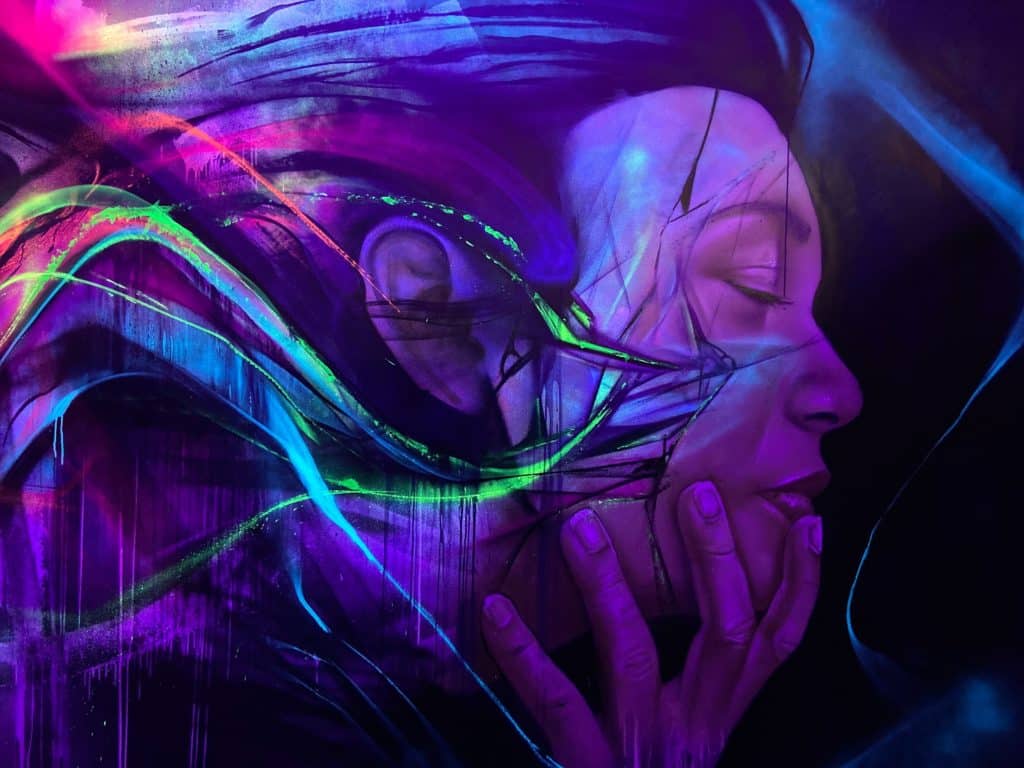 Painting of a woman holding her face in neon purples and greens by artist Liambononi at Colors Festival in Manchester