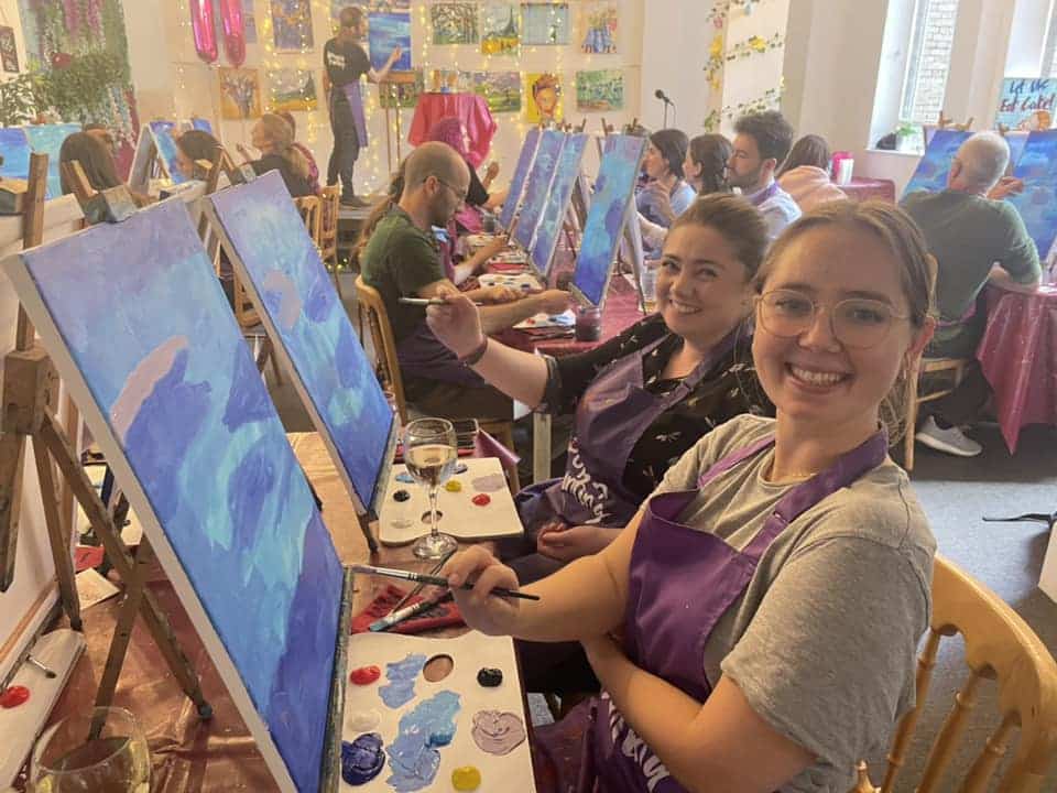pop-up-painting-ladies-smiling-next-to-canvases-at-painting-classes-manchester