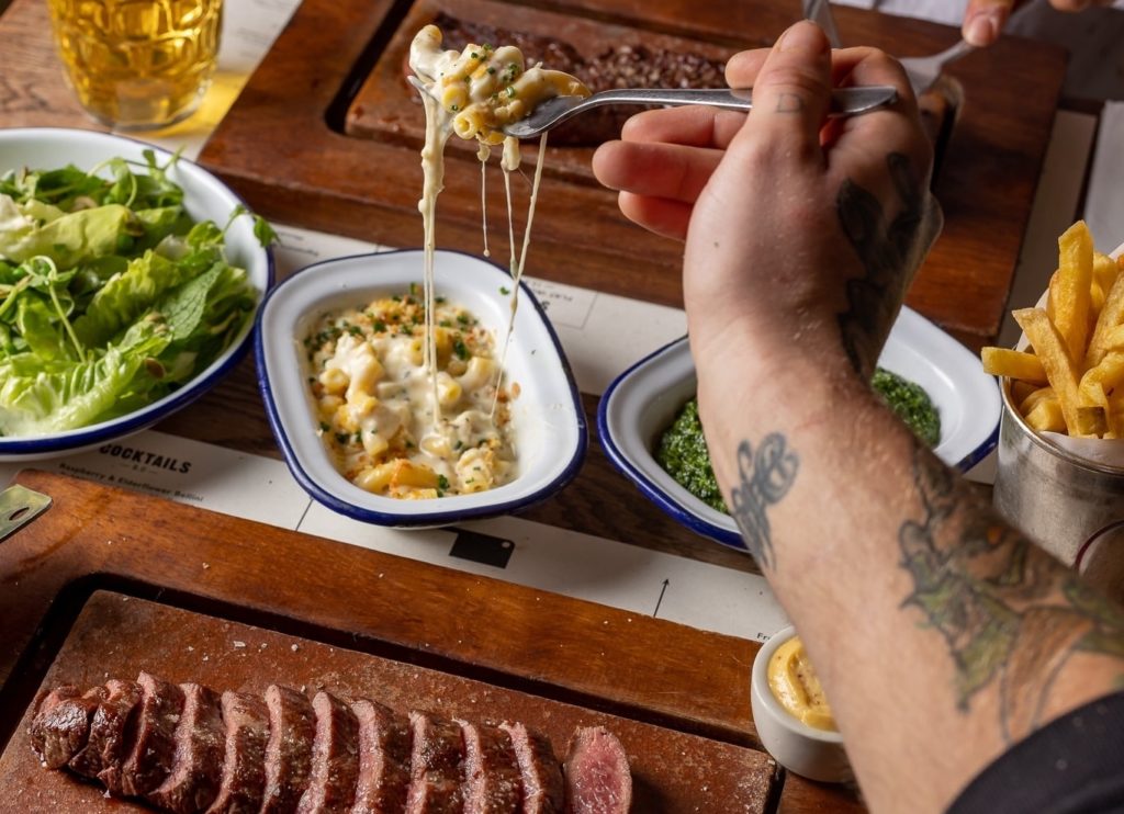 steak-salad-chips-and-person-tucking-into-macaroni-cheese