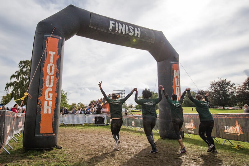 people-passing-tough-mudder-finish-line-the-assault-course-comes-to-manchester