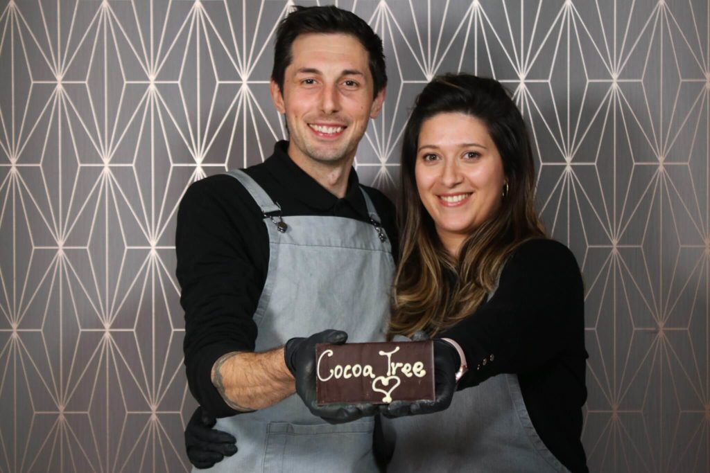 owners-of-cocoa-tree-holding-chocolate-bar-with-shop-name-on