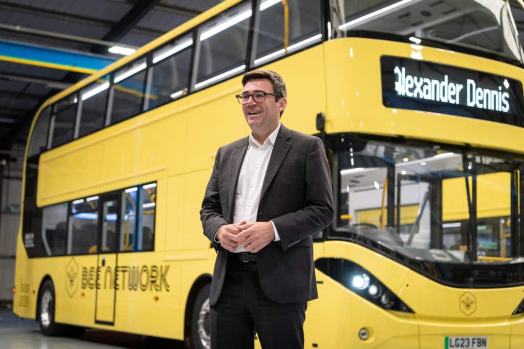 andy-burnham-in-front-of-yellow-bus-which-will-be-part-of-charity-bus-pull