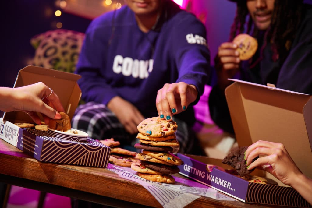 people-grabbing-cookie-from-stack-of-insomnia-cookies