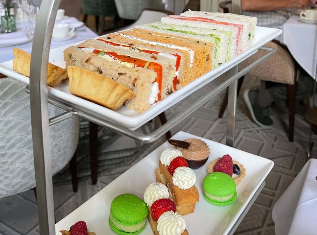 tiers-featuring-selection-of-sandwiches-and-sundried-tomato-tart-withcakes-macarons-below