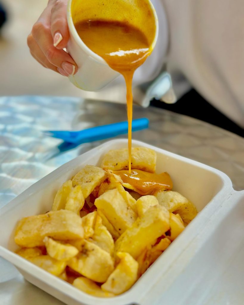thechipshop-pouring-curry-sauce-over-chips-late-night-food-manchester